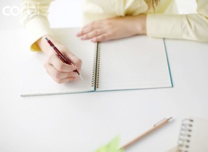 Woman Beginning to Write in Notebook
